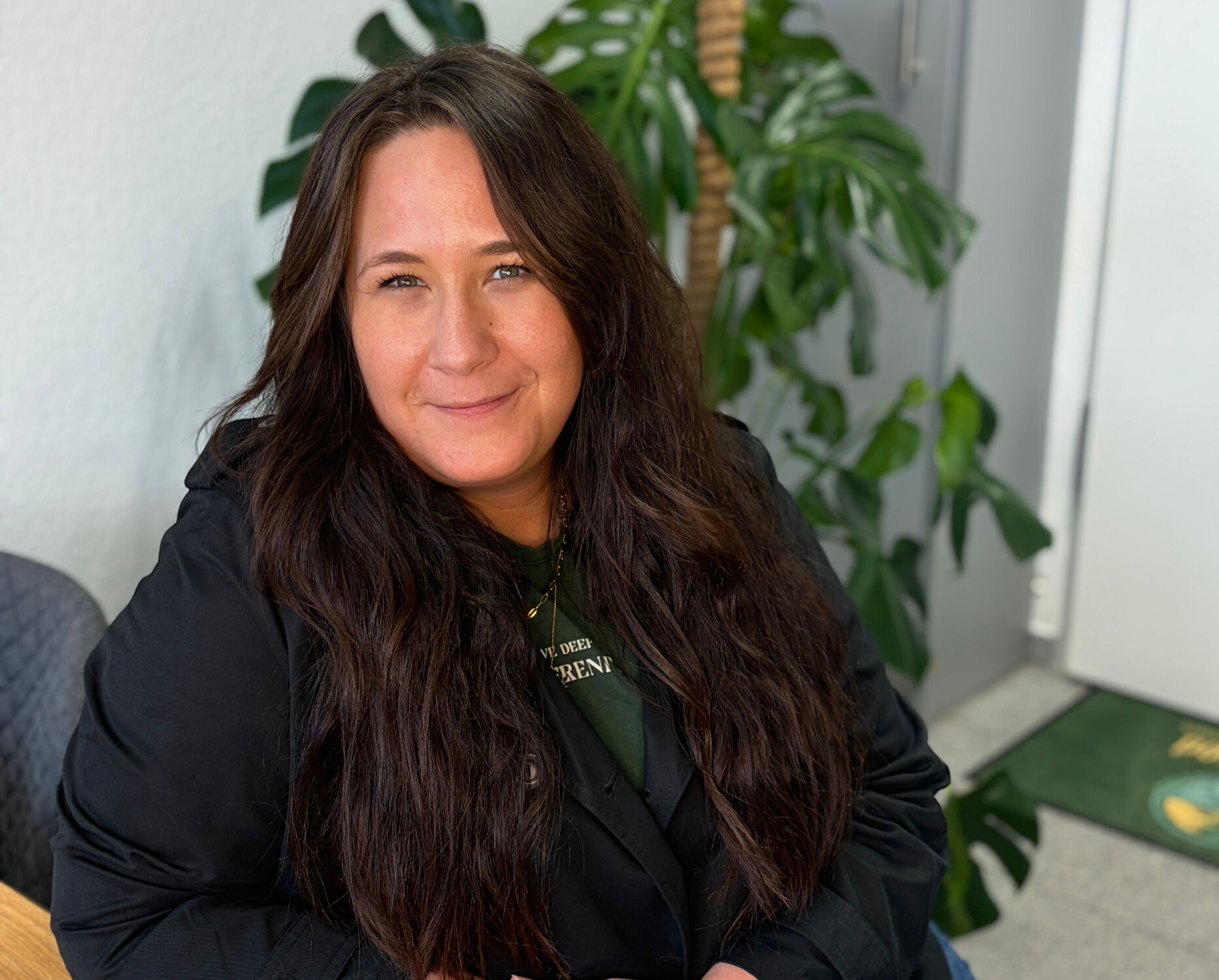 Confident businesswoman wearing glasses, talking on phone while reviewing documents in modern office setting.